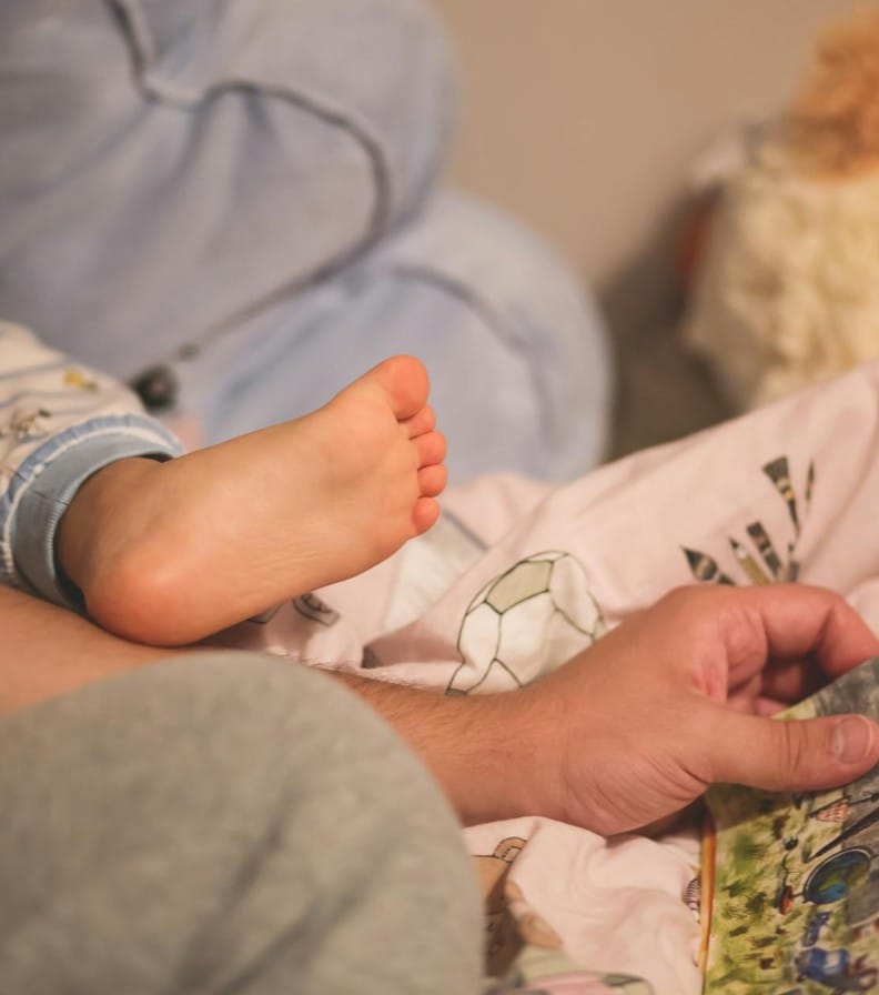 A warm, intimate moment of a child and parent reading a bedtime story together.